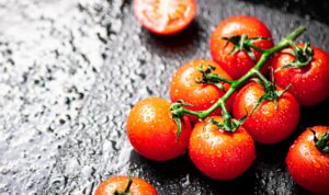 Clube da Horta - Tomates frescos e fatias de tomate em cima da mesa.
